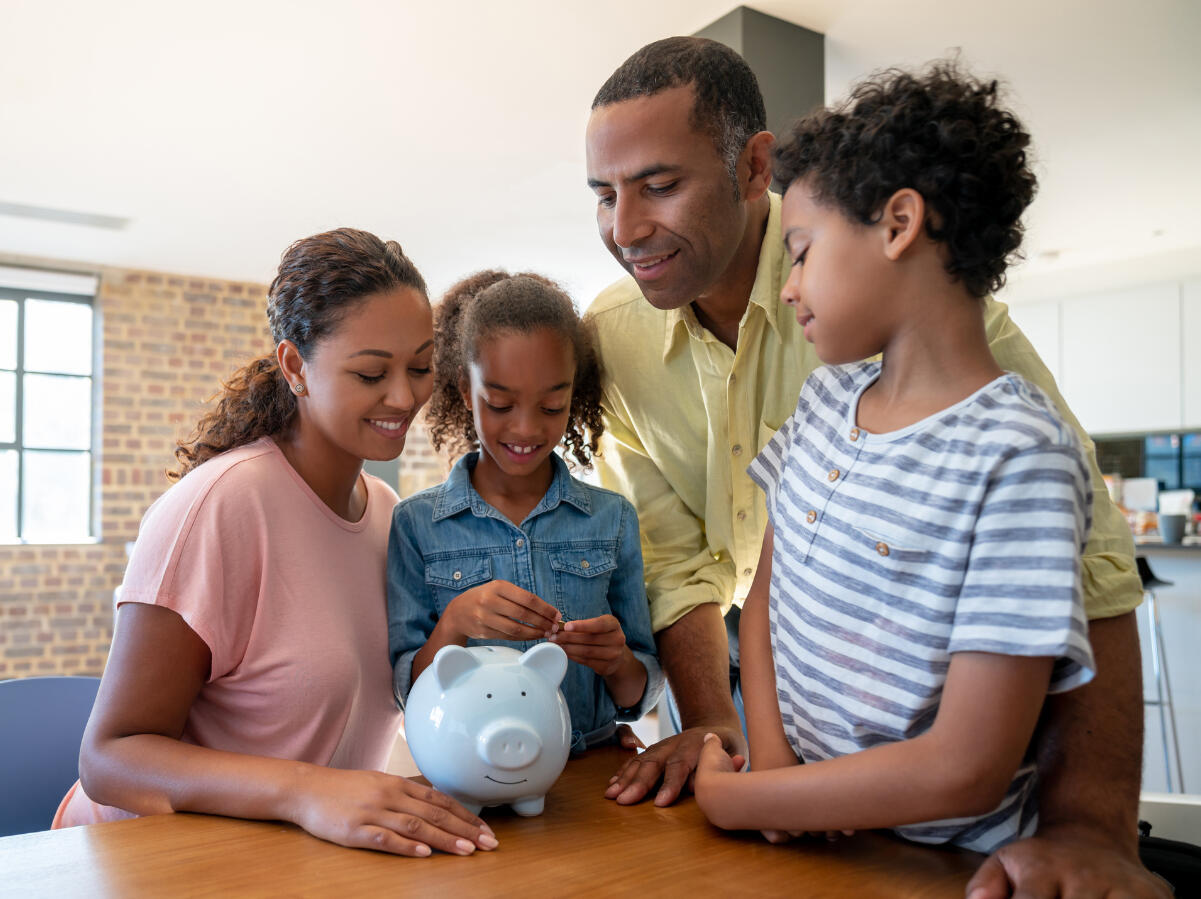 Family around a table counting the savings into a piggy bank